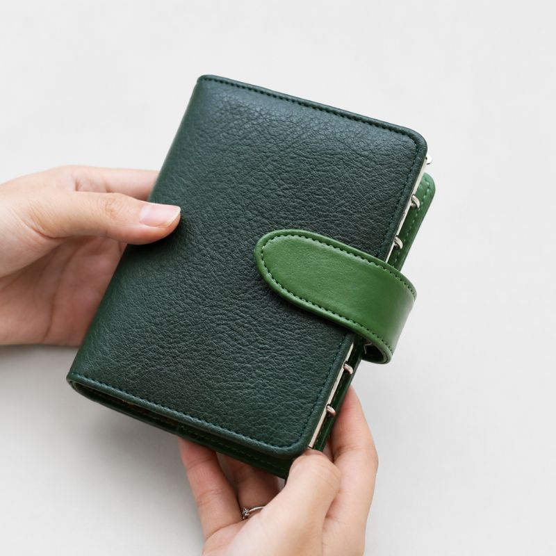 Closed Midnight Forest green leather Nomad kit held in hand