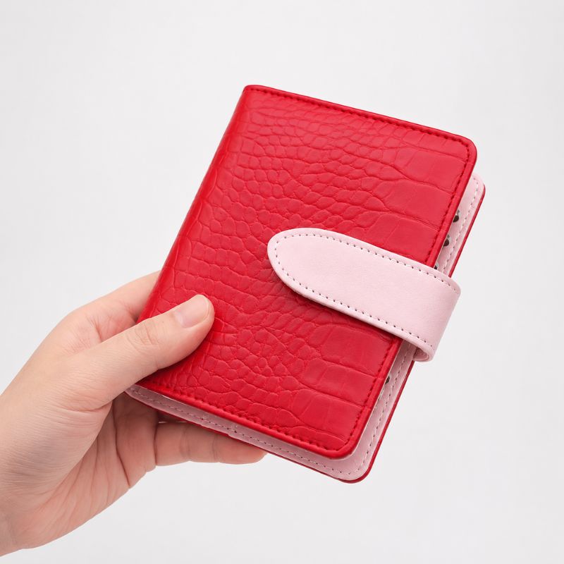 Closed red crocodile-texture Nomad kit with pink trim